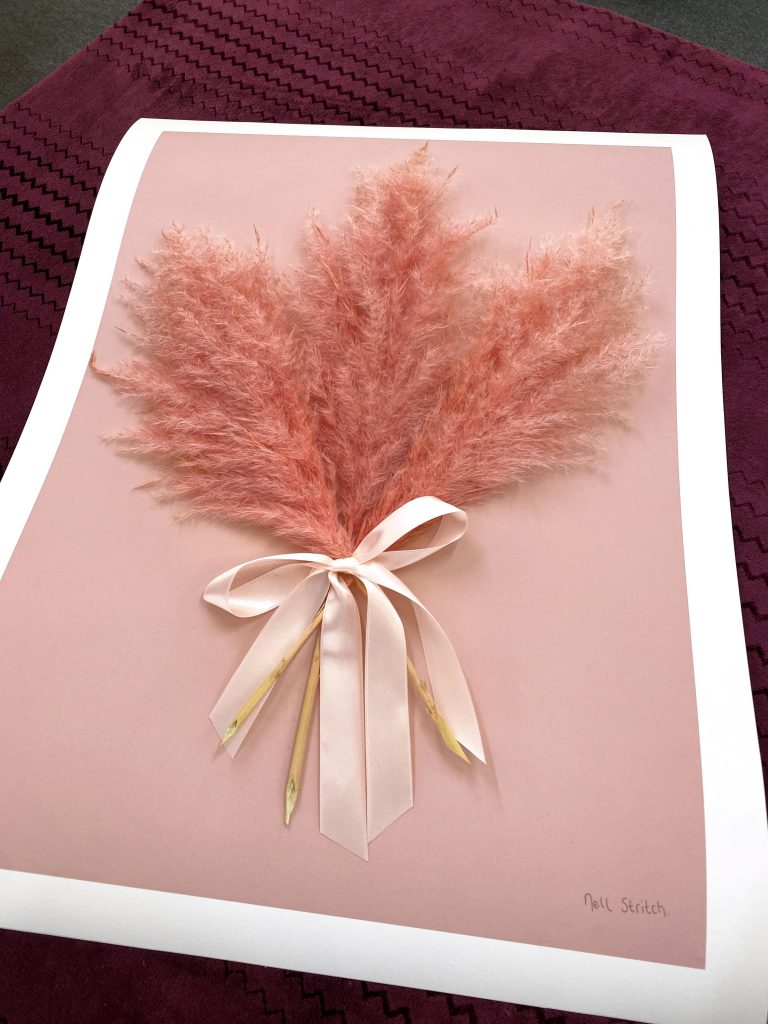 Print of pink ferns tied with a pink bow, on a pink table